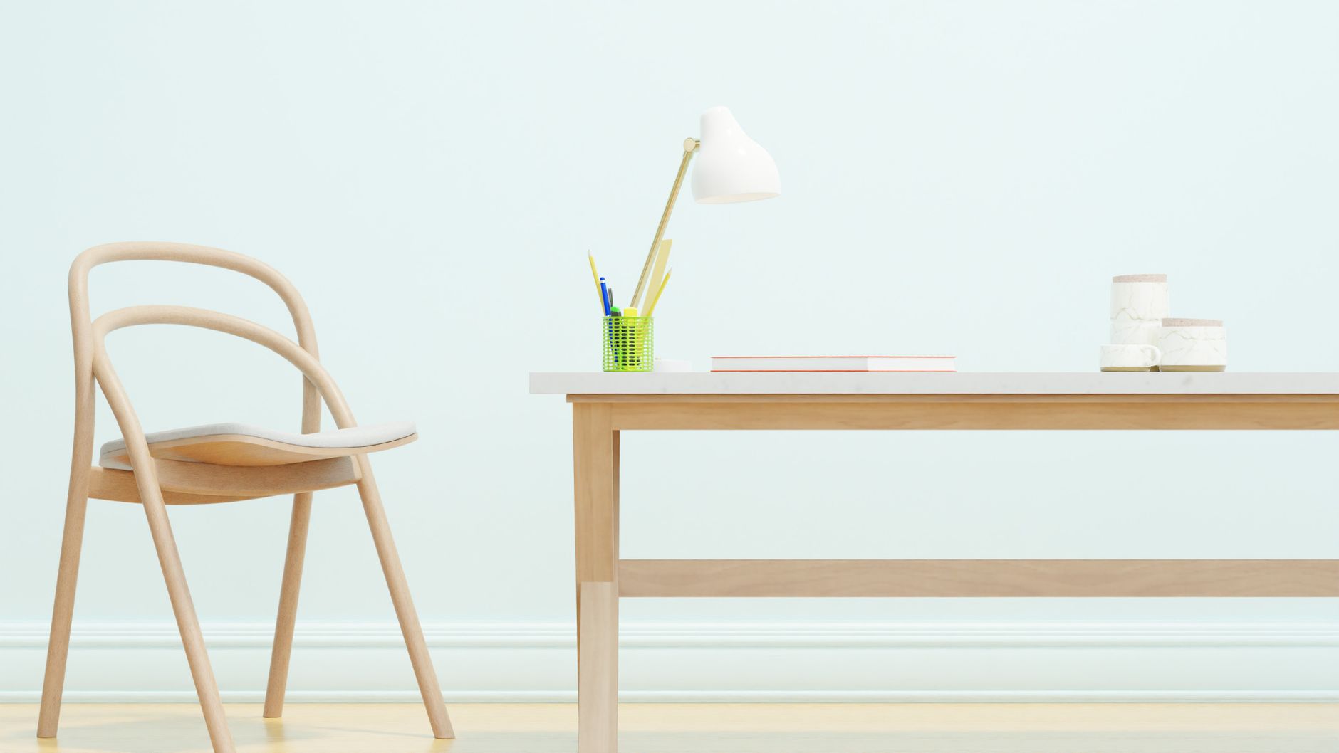 Sedia in legno chiaro e tavolo con lampada bianca, penne e libri su sfondo azzurro.